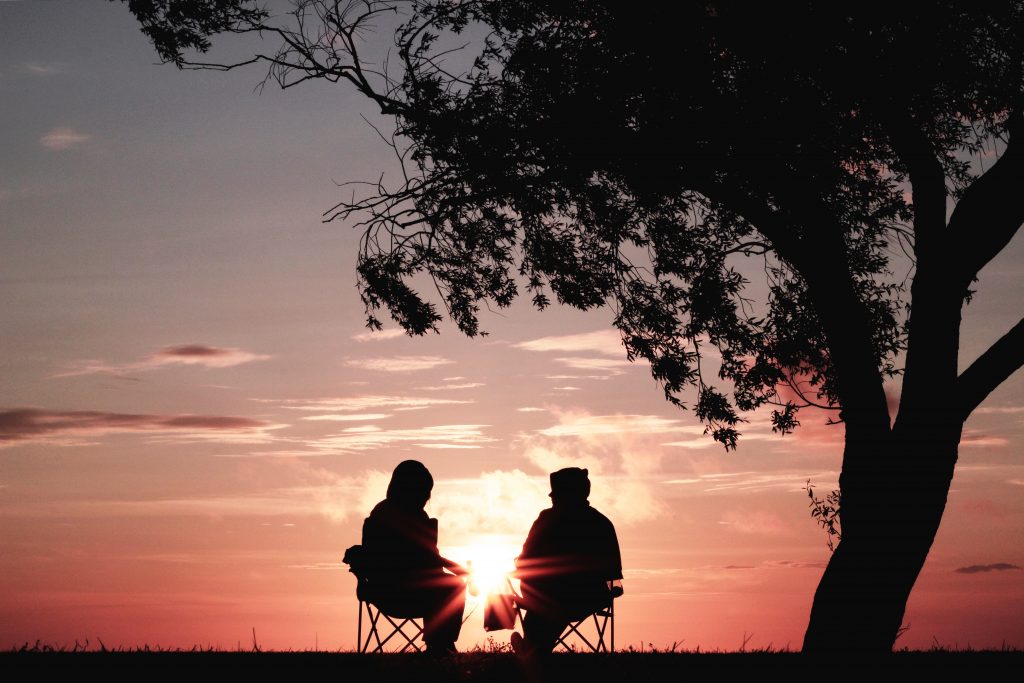couple in conversation facing sunset