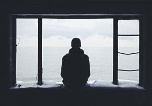 man alone looking out the window